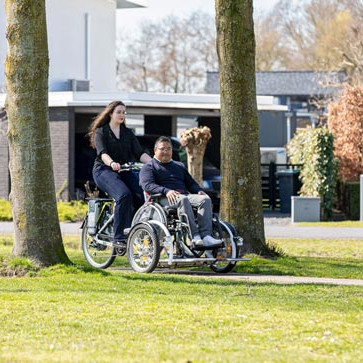 VeloPlus Rollstuhlfarrad von Van Raam mit Rollstuhlfahrer auf einem Fahrradweg.